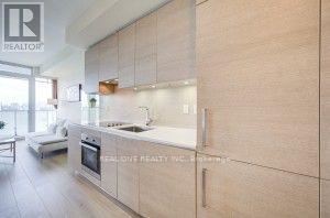 A modern kitchen with wooden cabinets and a stainless steel stove.