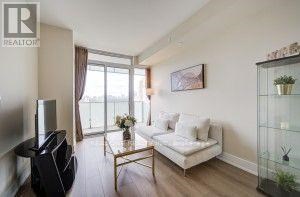 A living room with a white couch and a glass coffee table.