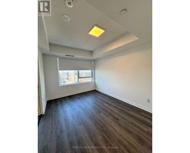 A room with wooden flooring and a window with blinds.