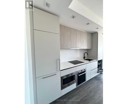 A modern kitchen with white cabinets and appliances.