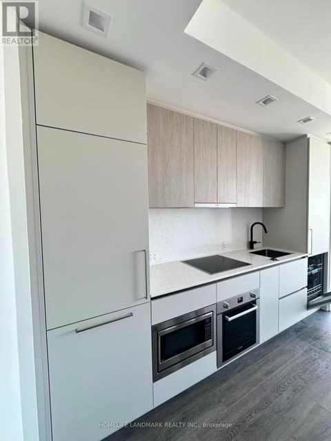 A modern kitchen with white cabinets and appliances.