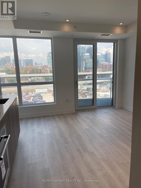 A spacious room with a view of the cityscape through large windows.