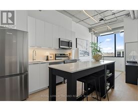 A modern kitchen with a large island and stainless steel appliances.