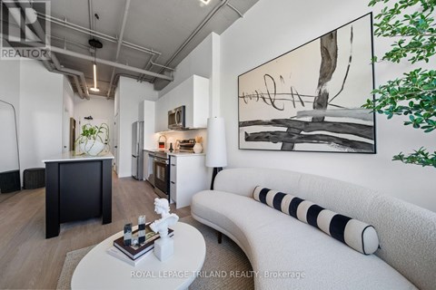 A modern living room with a large painting on the wall and a white sofa.