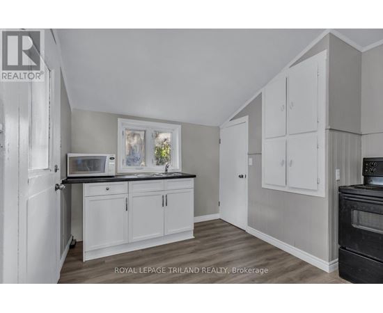 A kitchen with white cabinets and a black stove top oven.