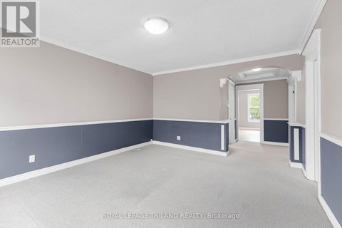 A spacious room with a doorway leading to another room.