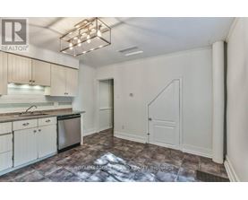 A kitchen with a refrigerator, sink, and cabinets.