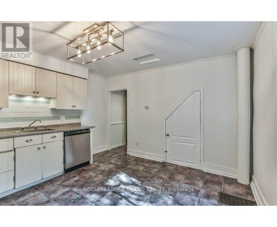 A kitchen with a refrigerator, sink, and cabinets.