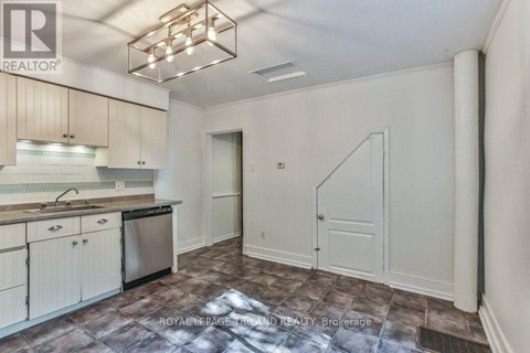 A kitchen with a refrigerator, sink, and cabinets.