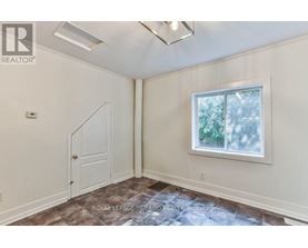 A room with a door and a window with a view of trees.