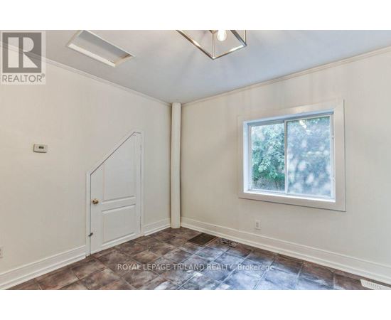 A room with a door and a window with a view of trees.