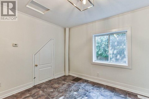 A room with a door and a window with a view of trees.