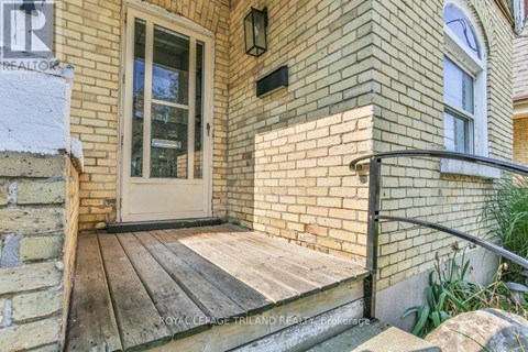 A house entrance with a glass door and a wooden step.