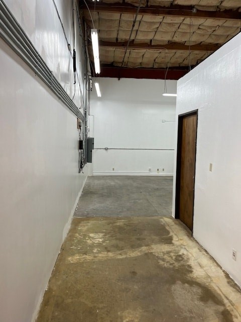 A long, empty hallway with a door on the right and a wall on the left.