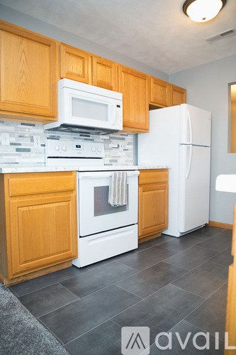 A kitchen with wooden cabinets and white appliances.