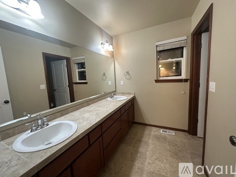 A bathroom with a sink, mirror, and light fixture.