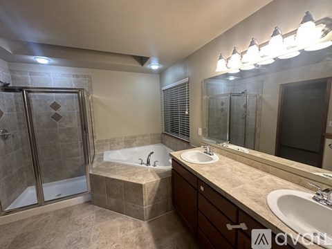 A modern bathroom with a large tub and double sinks.