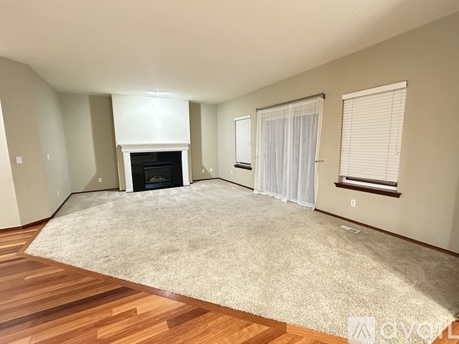 A living room with a fireplace and a rug.
