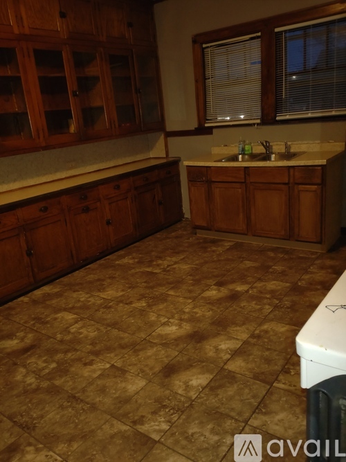 A kitchen with brown cabinets and a tiled floor.