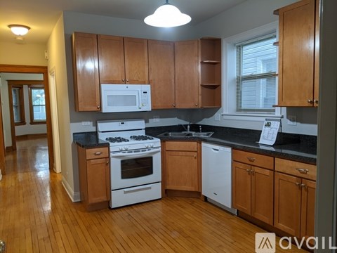 A kitchen with wooden cabinets and black countertops.