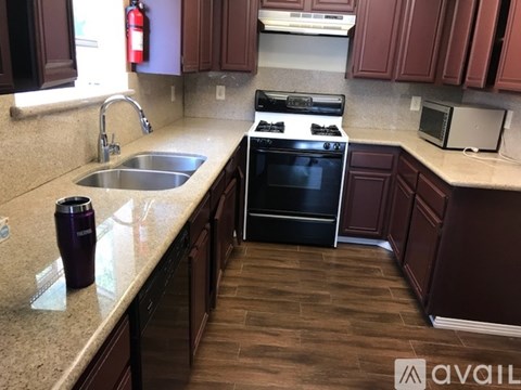 A kitchen with a black stove top oven and a black microwave.