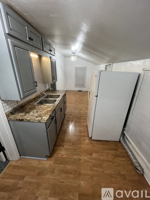 A kitchen with a granite countertop and wooden flooring.
