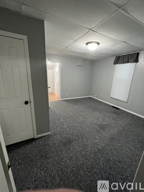 A room with grey carpet and white walls.