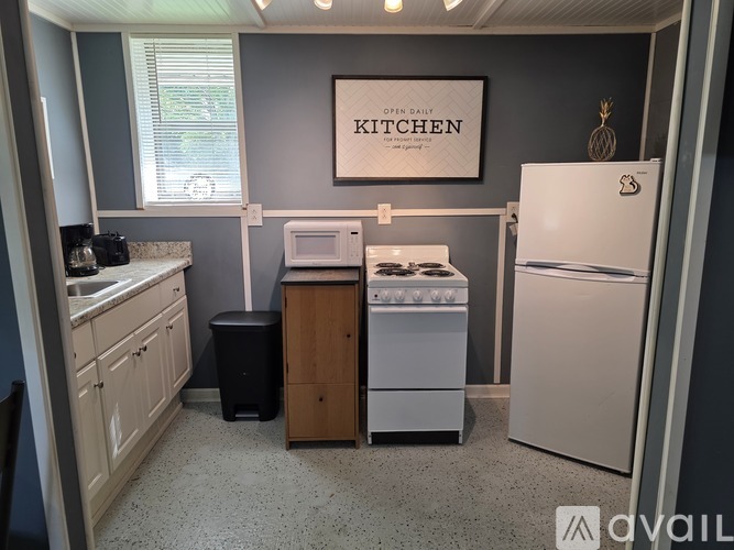 A kitchen with a white refrigerator, a white microwave, a white oven, and a white sink.