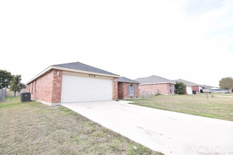 A house with a garage and driveway in front.