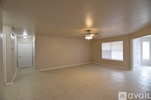 A spacious room with a ceiling fan and tiled flooring.
