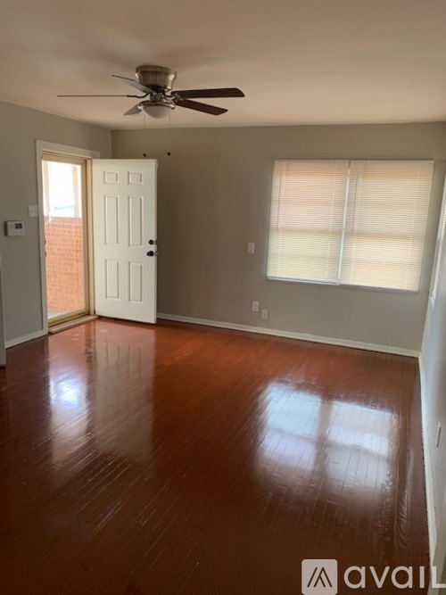 A room with a ceiling fan and a door leading to a balcony.