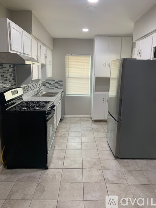 A kitchen with a black stove top oven and a black refrigerator.