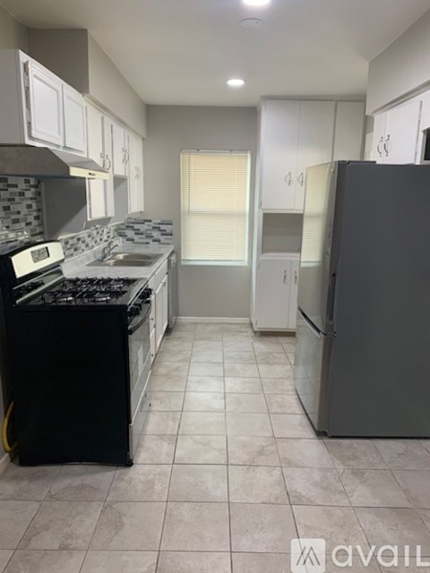 A kitchen with a black stove top oven and a black refrigerator.