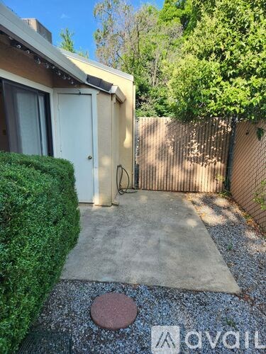 A backyard with a concrete patio and a brick in the middle.