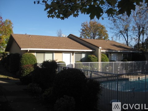 A house with a brown roof and a pool in the backyard.