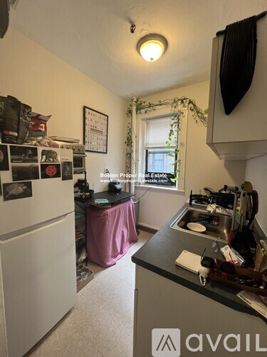 A kitchen with a white refrigerator and a black counter.