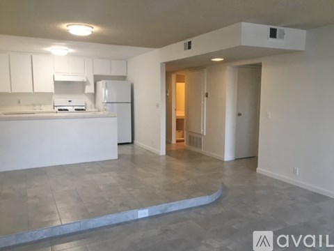 A kitchen with white cabinets and a white fridge with a countertop and a sink.