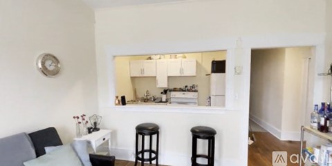 A living room with a grey sofa and a white table.