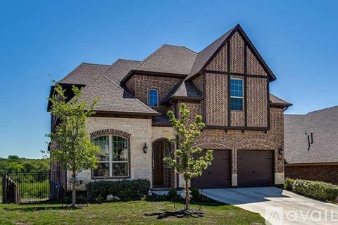 A large house with a black roof and a garage door.