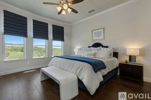 A bedroom with a large bed and a ceiling fan.