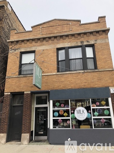 A brick building with a window that has a sign that says "milk supply".