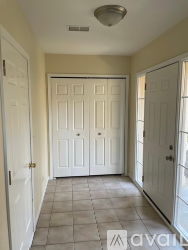 A hallway with a white door in the middle and two white doors on the sides.
