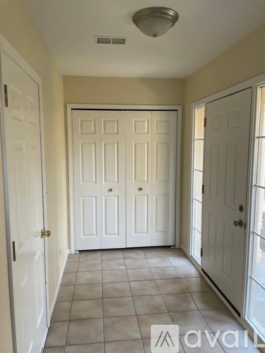 A hallway with a white door in the middle and two white doors on the sides.