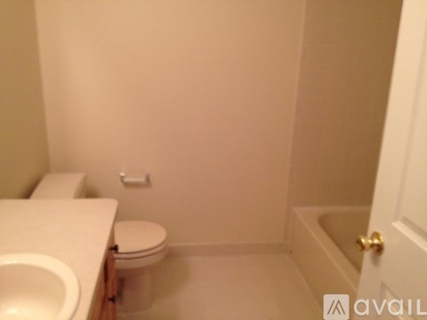 A bathroom with a toilet, sink, and bathtub.