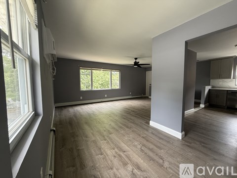 A spacious room with a ceiling fan and large windows.