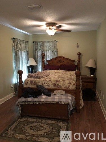 A bedroom with a large bed and a ceiling fan.