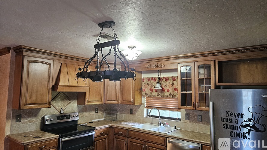 A kitchen with wooden cabinets and a black stove top oven.