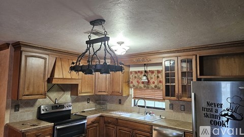 A kitchen with wooden cabinets and a black stove top oven.