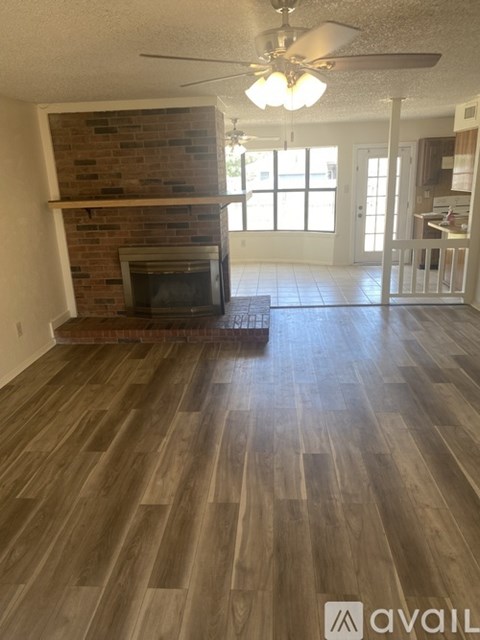 A living room with a fireplace and wood flooring.