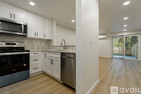 A modern kitchen with white cabinets and stainless steel appliances.